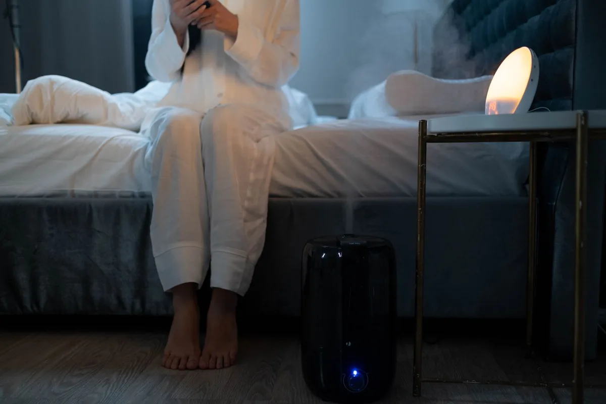 Mist rising from a humidifier in a softly lit bedroom