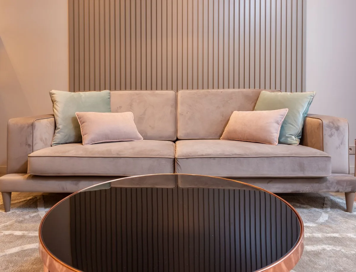A round coffee table in front of a beige sofa