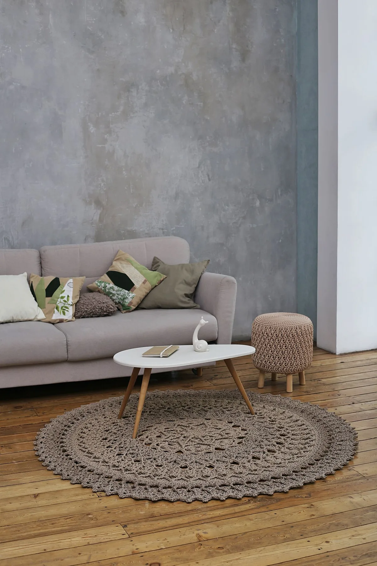 A living room with a gray sofa, circular rug and coffee table