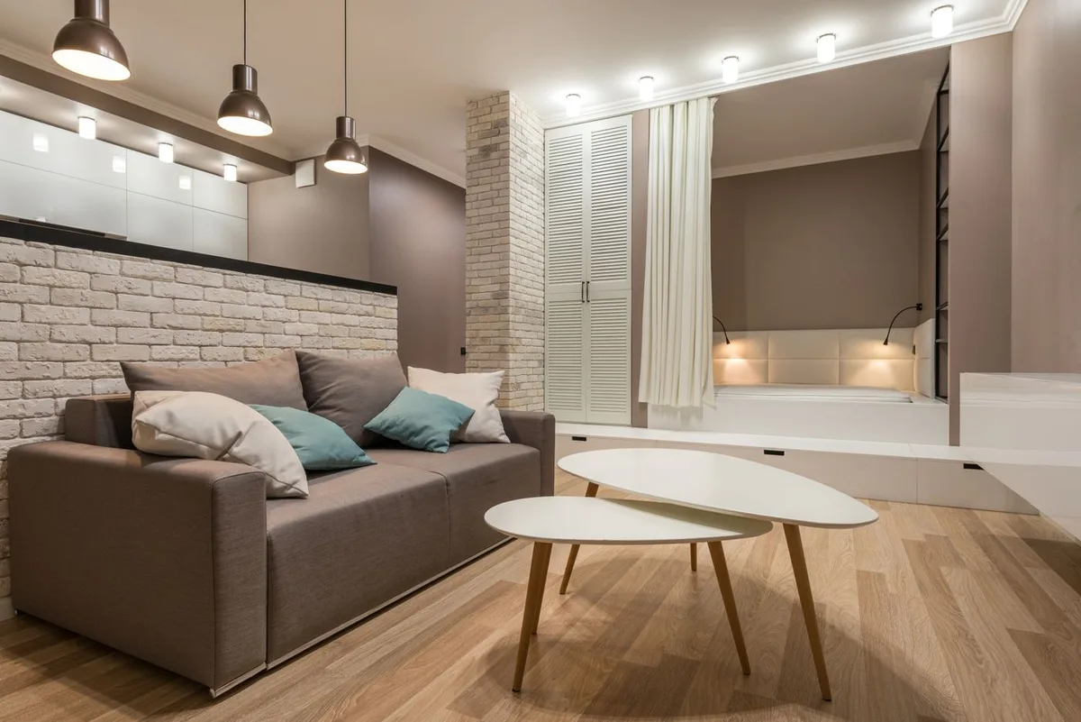 A living room with a sofa, pendant lamps and ceiling lighting